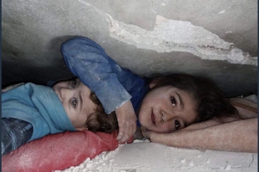 シリア地震で倒壊した建物で弟を守っている10歳の姉jpg