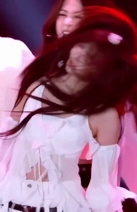 ル・セラフィム・ウンチェは、紐タンクトップとシルクのような谷間を備えた白いシースルー衣装を着ています。