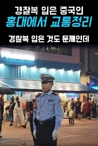 警察官のコスプレをした中国人男性が弘大で交通整理をしている。