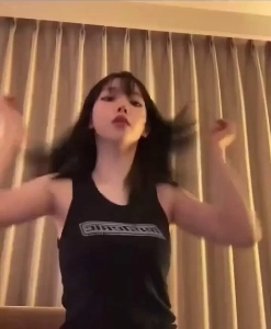 カリーナは髪をラバンに上げてイチャイチャし、重い黒のノースリーブを着ている